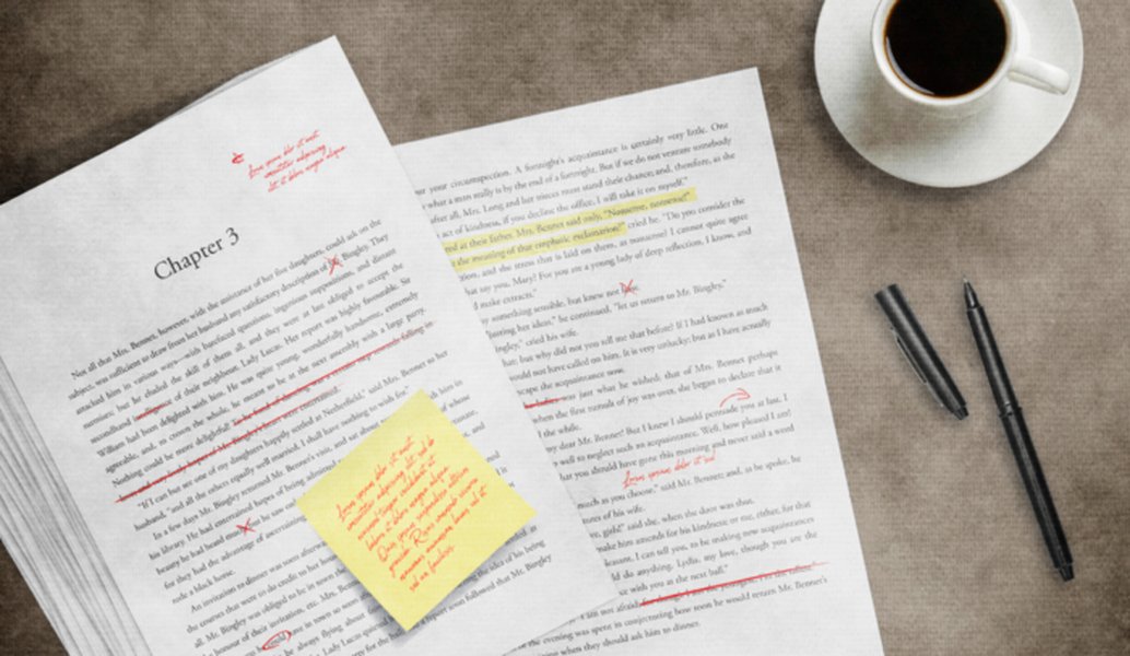 Hands editing a manuscript with red pen