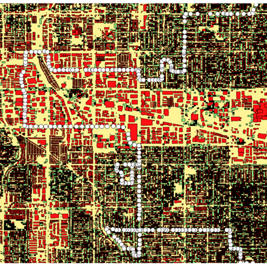 This is a pixelated, color-coded urban map filled with red, beige, green, and black blocks. A prominent white dotted line winds across the grid, tracing a specific route through the city.