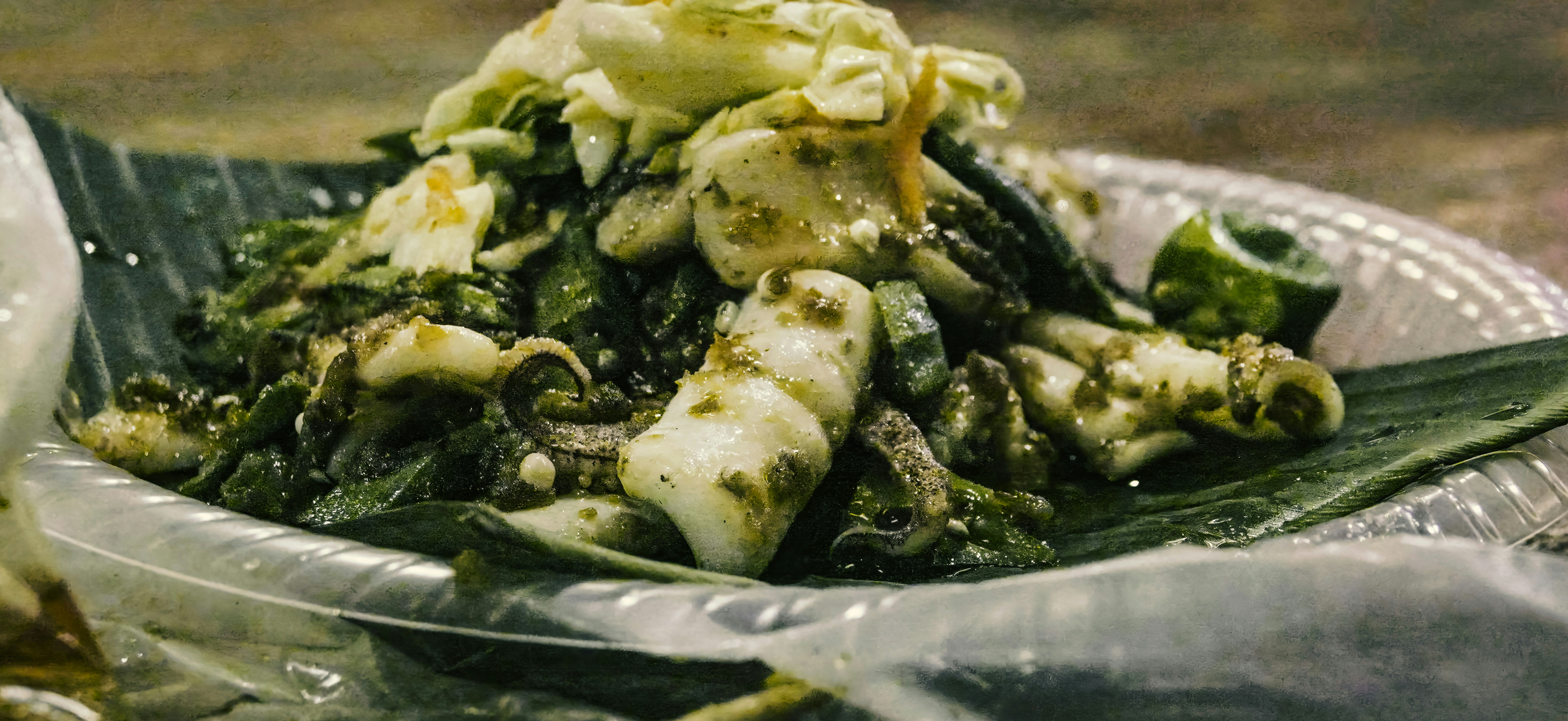 Squid and vegetables served on a banana leaf.