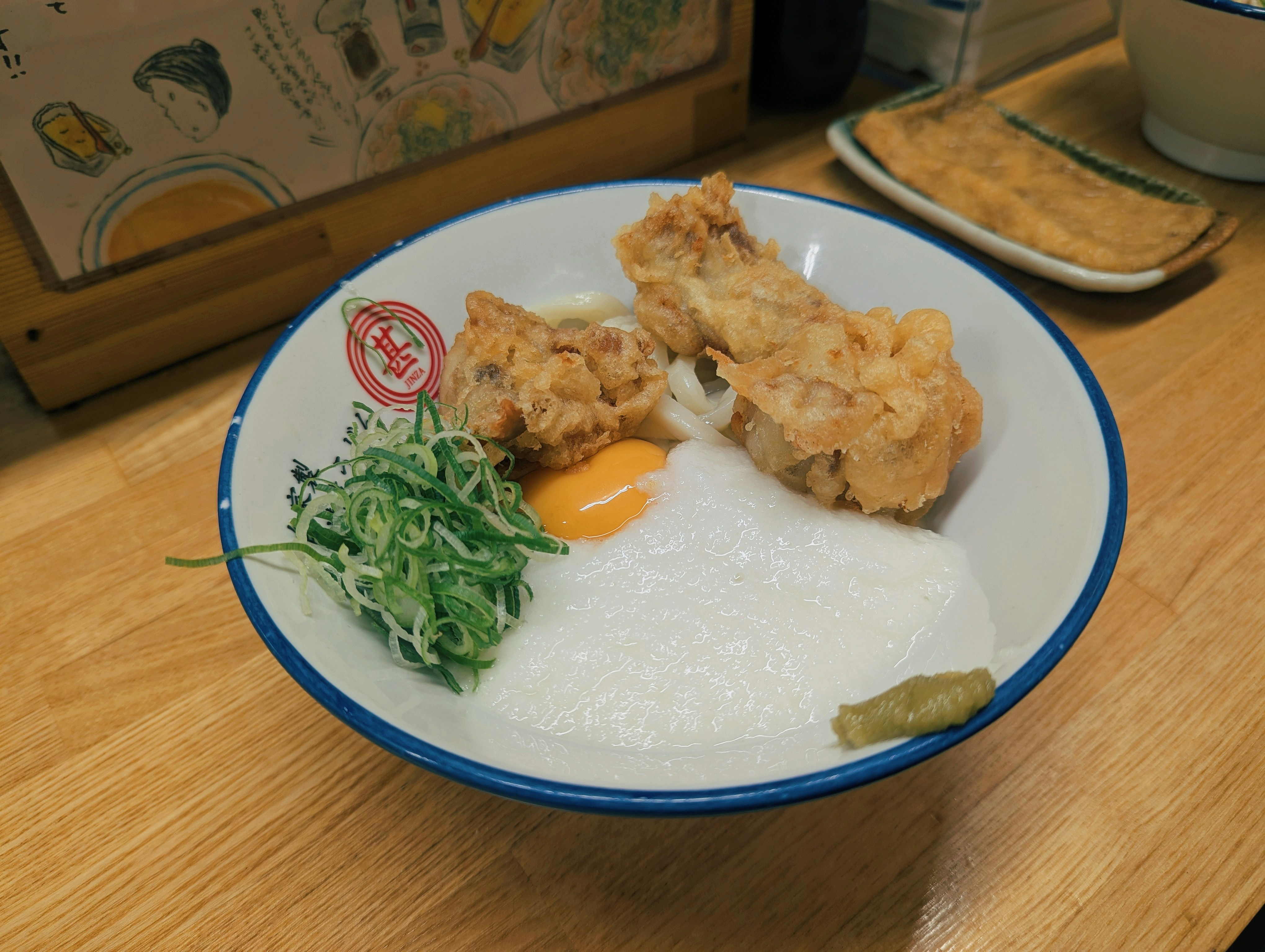 Fried chicken and egg over rice with scallions.