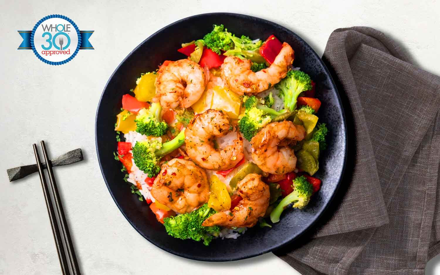 Shrimp stir fry with cauliflower rice, teriyaki glaze, roasted bell peppers, broccoli, and topped with sesame seeds. 