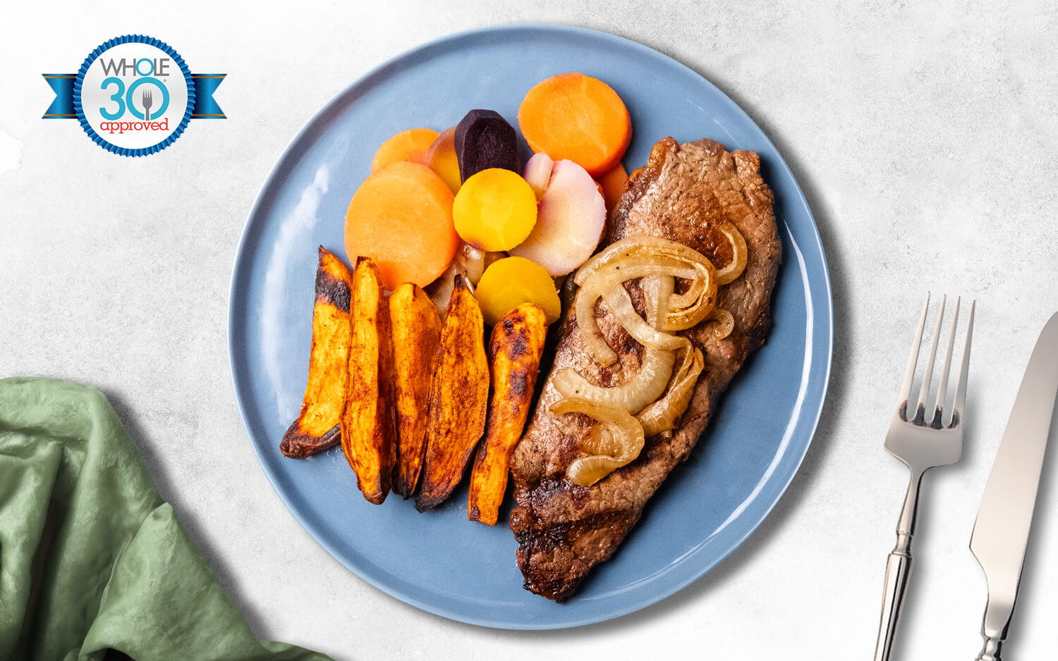 New York Strip Steak served with Sweet Potato Fries, Multi-Color Carrot Blend and Caramelized Onions.