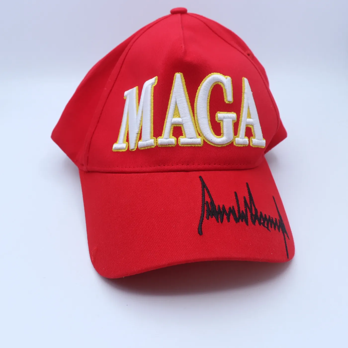 كاب أحمر بشعار MAGA وتوقيع