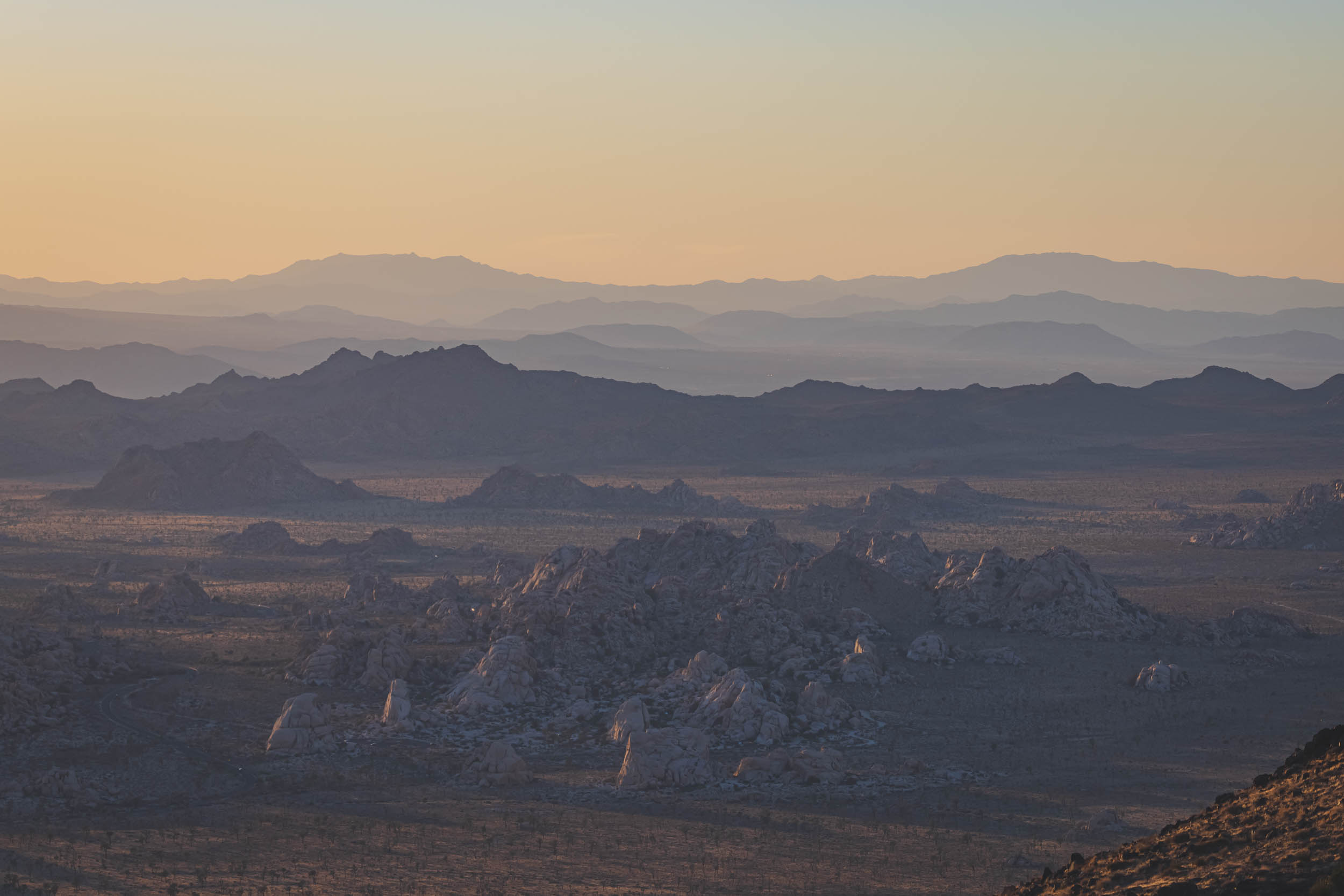Late in the day as the mountains and rocks in Joshua Tree National park reflect colorful light