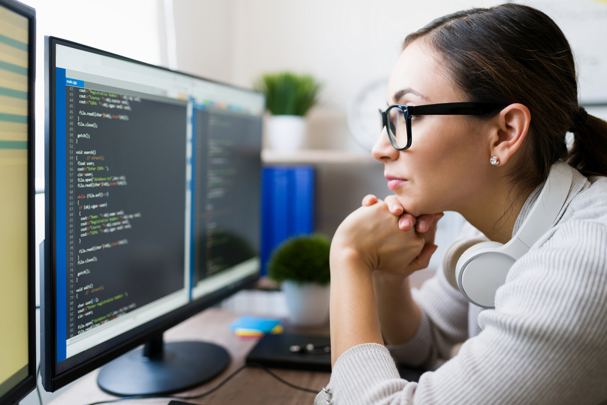 female-contractor-wearing-glasses-while-reading-the-coding-software-on-the-computer