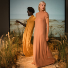 Two women wearing floor-length modal dresses in earth tones.