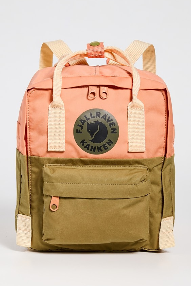 a fjallraven kanken art mini backpack, with a handle on top and a color block scheme with pink and green.