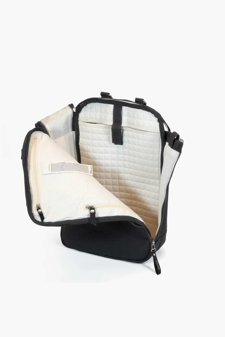 a black bananatex day pack half opened to show the checkered texture of the inside