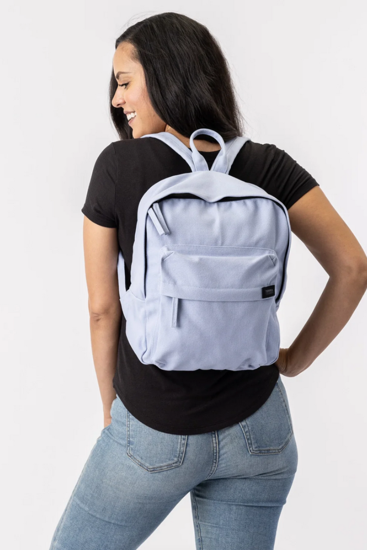 a person models a light purple zen mini bag from terra thread. it's the same style as the first image, but without side pockets and smaller.