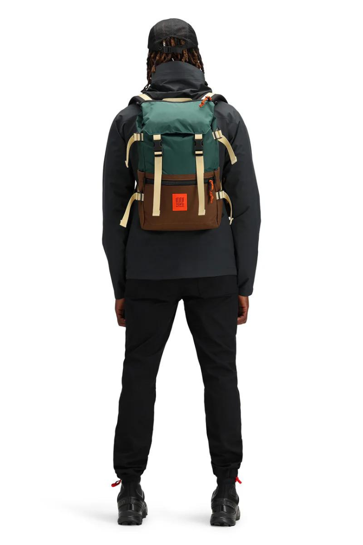 a person in all black models a rover pack classic in dark green, brown, and red