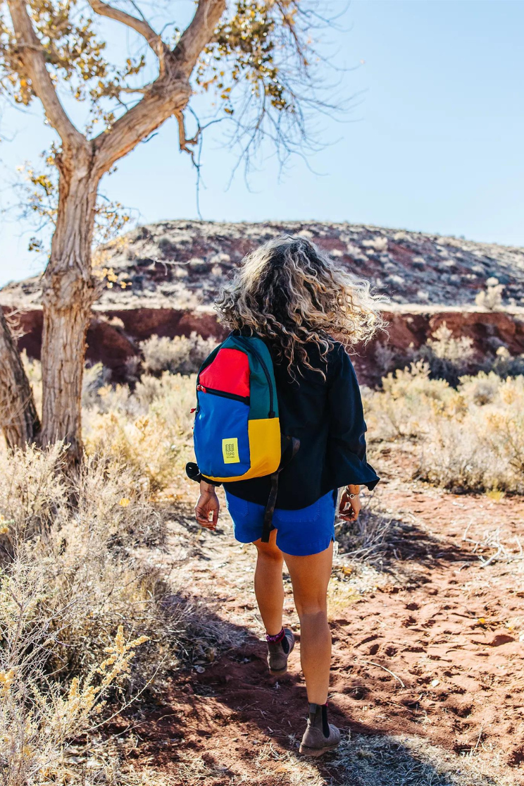 a person models a multicolored backpack outdoors