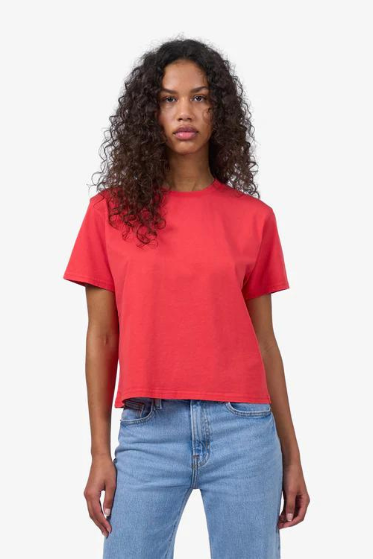 a woman models a boxy hot pink tee with light wash jeans