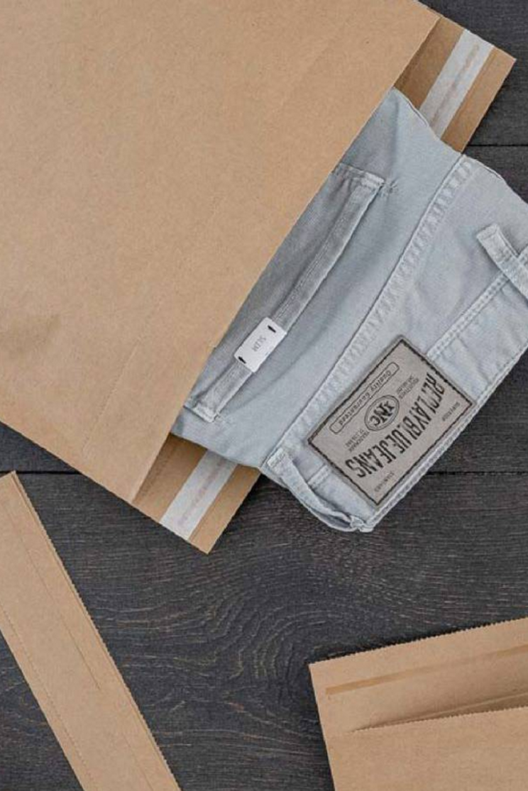 a pair of jeans sticking out of a recyclable paper mailer