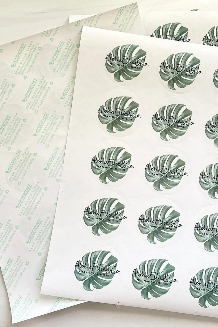 a sheet of logo stickers of monstera leaves and a brand name