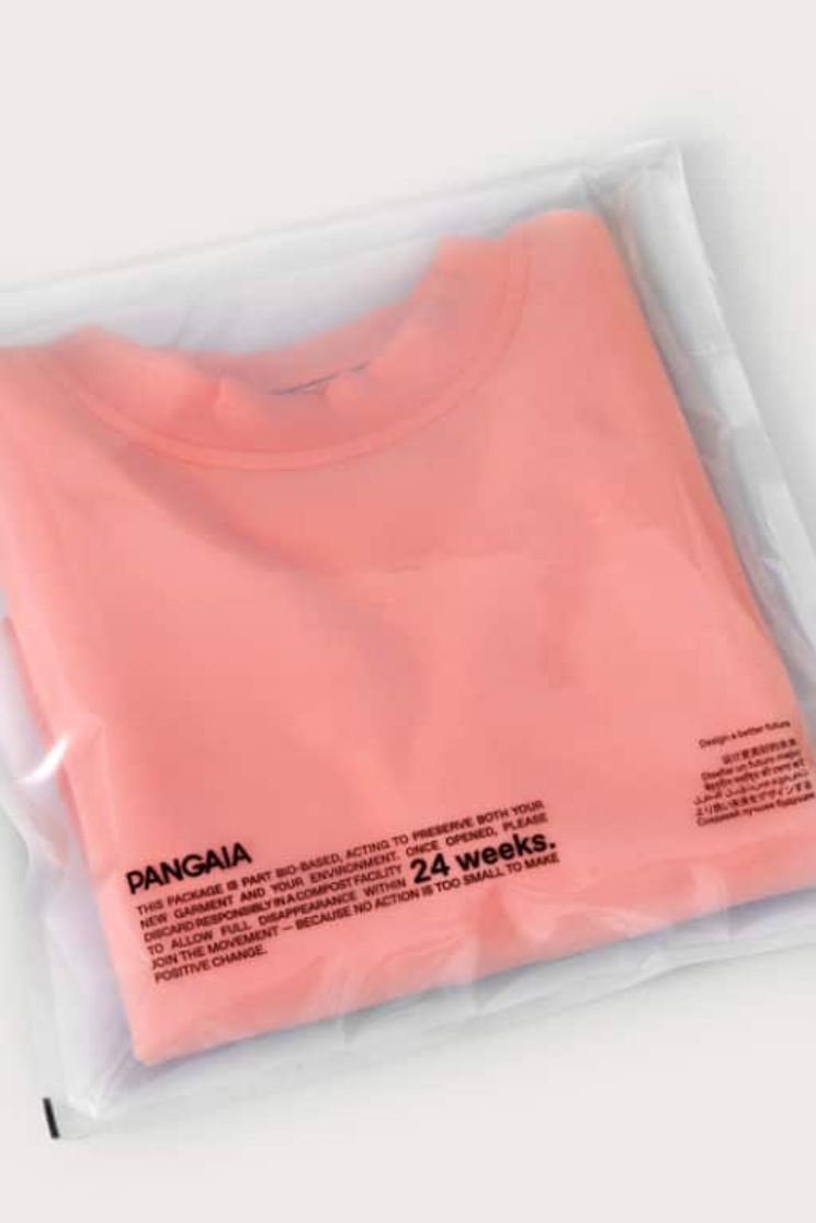 a pink shirt in a compostable flap pouch with the brand "Pangaia" printed on it.
