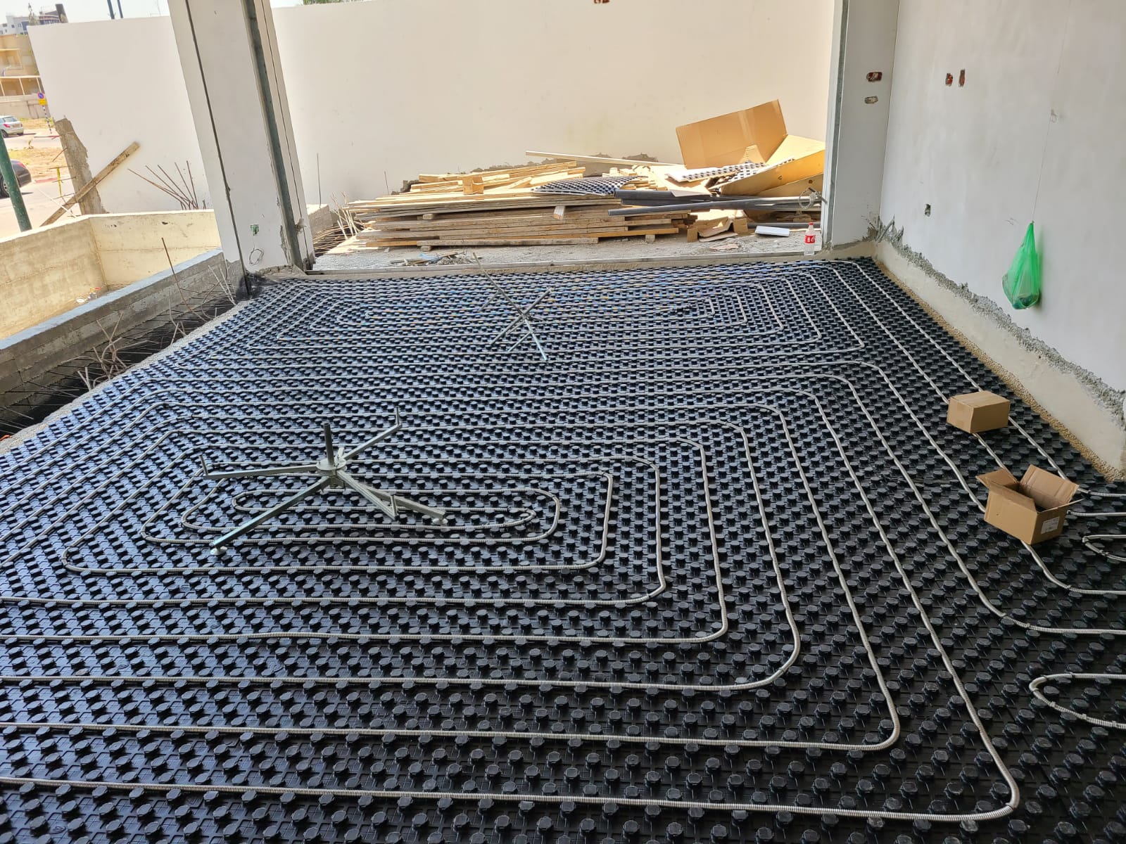 צנרת נירוסטה ECOHEAT באתר בנייה — התקנה על לוחות בידוד תרמי