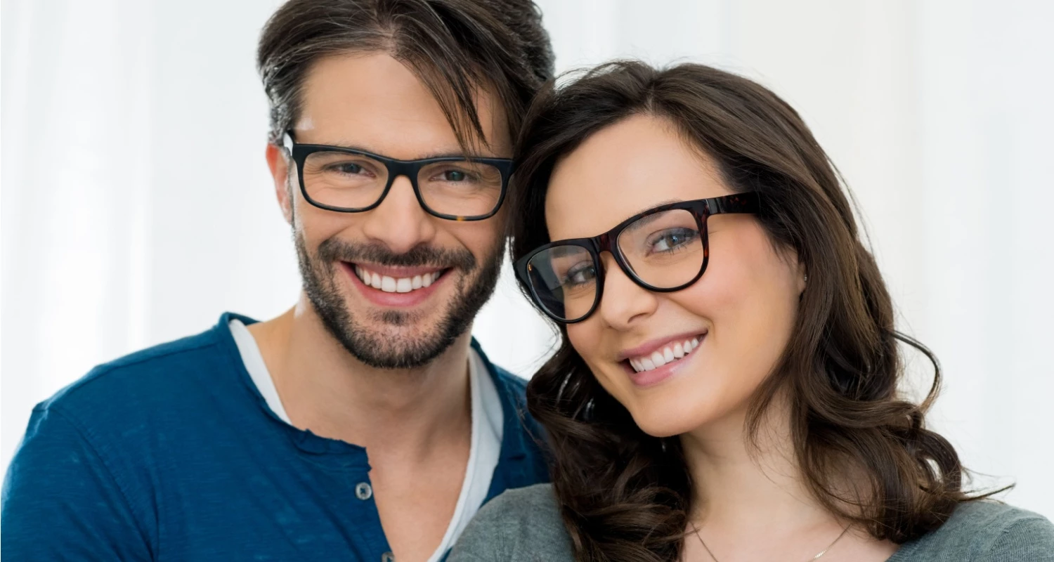 Smiling man and woman with eyeglasses.