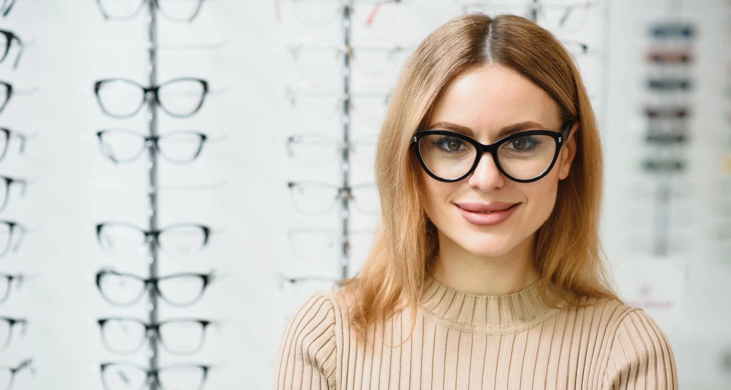 Female at eye doctors office tryin on eye glasses.