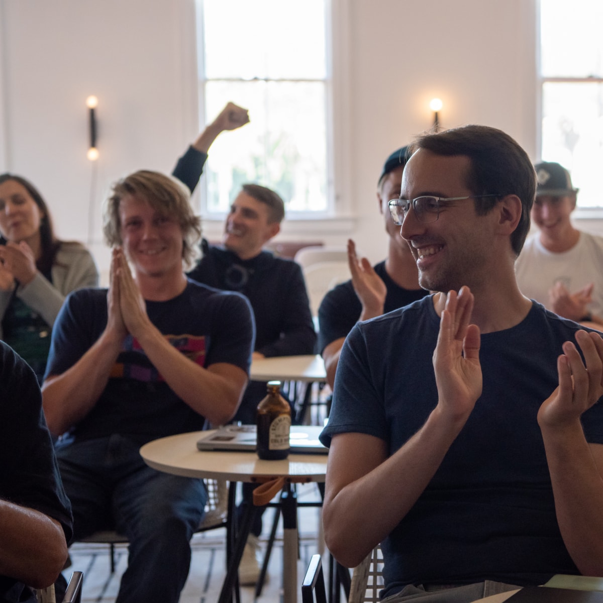 A small audience clapping and cheering