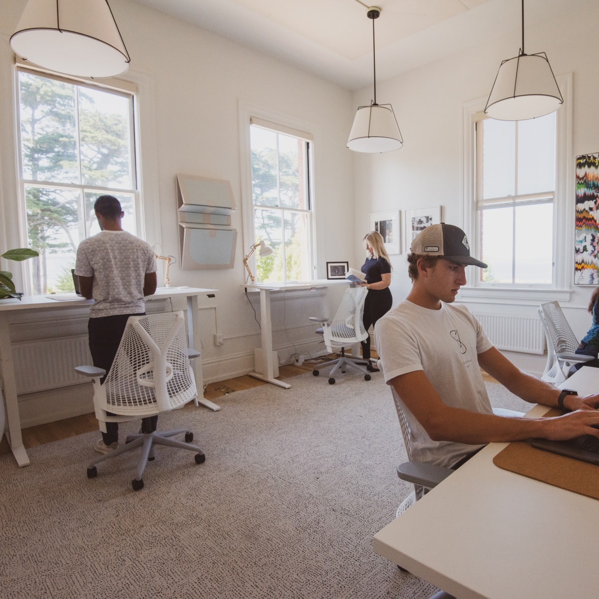 Three people working at standing desks