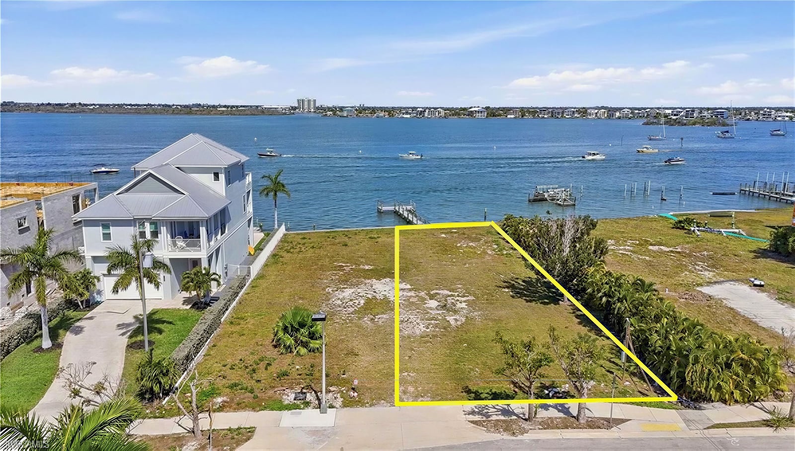 Vacant waterfront lot with yellow boundary on an aerial photo