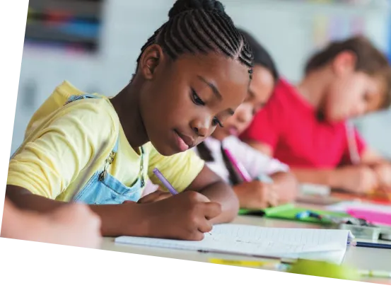 Imagem de três crianças escrevendo em seus respectivos cadernos.