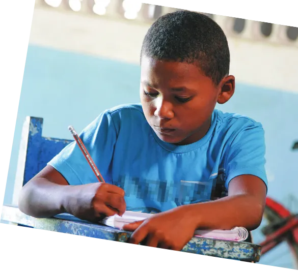 Imagem de um aluno escrevendo em um caderno.