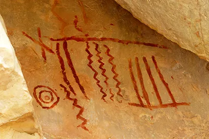 Imagem de pintura rupestre com traços e círculos.