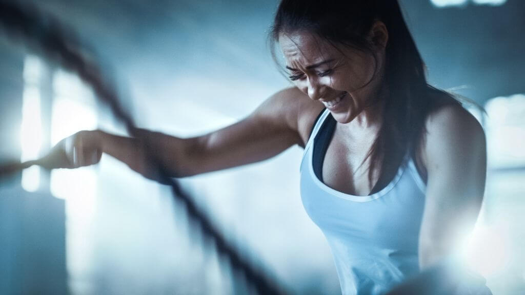 Woman doing a HIIT workout with ropes