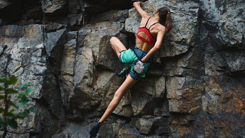 Young woman free climbing