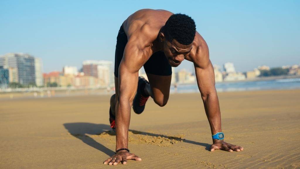 Young muscular man working out at the beach