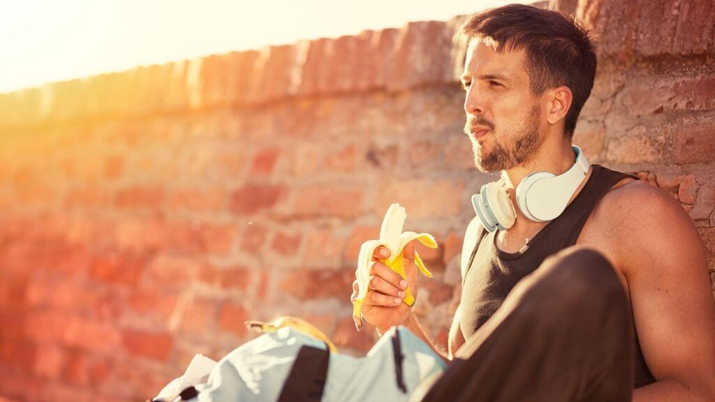 Young man having a banana before work out