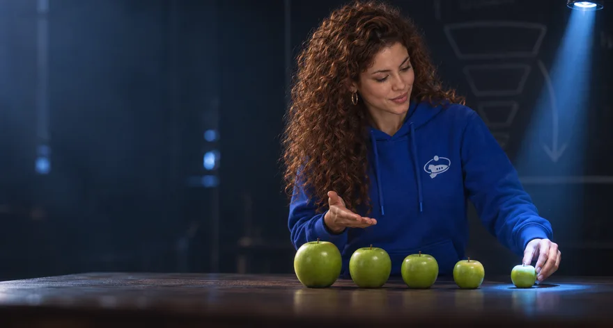 Una estratega con hoodie de Efeonce explica un embudo de marketing con cinco manzanas verdes