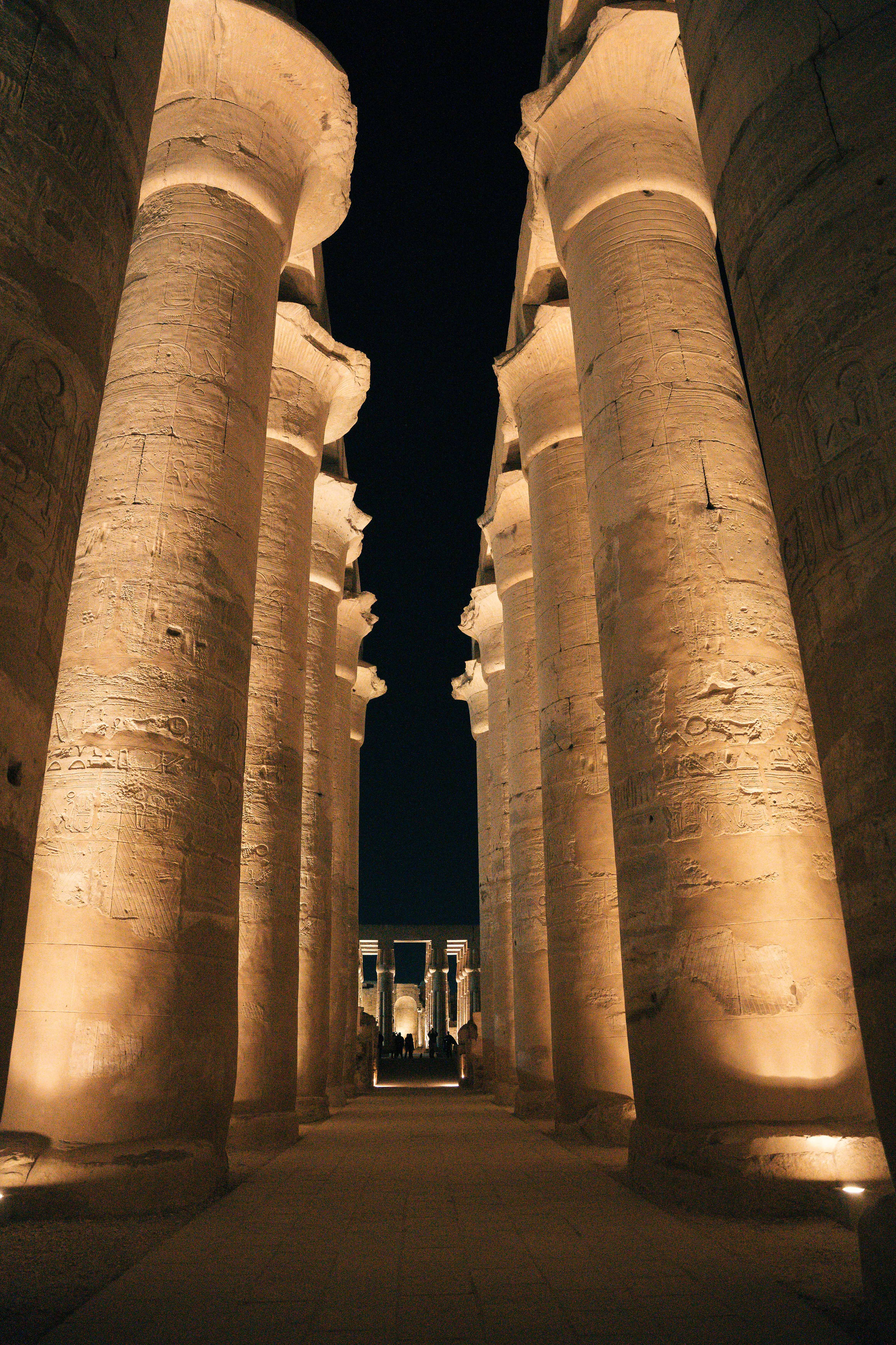 Total solar eclipse framed between the silhouetted columns of a Luxor temple