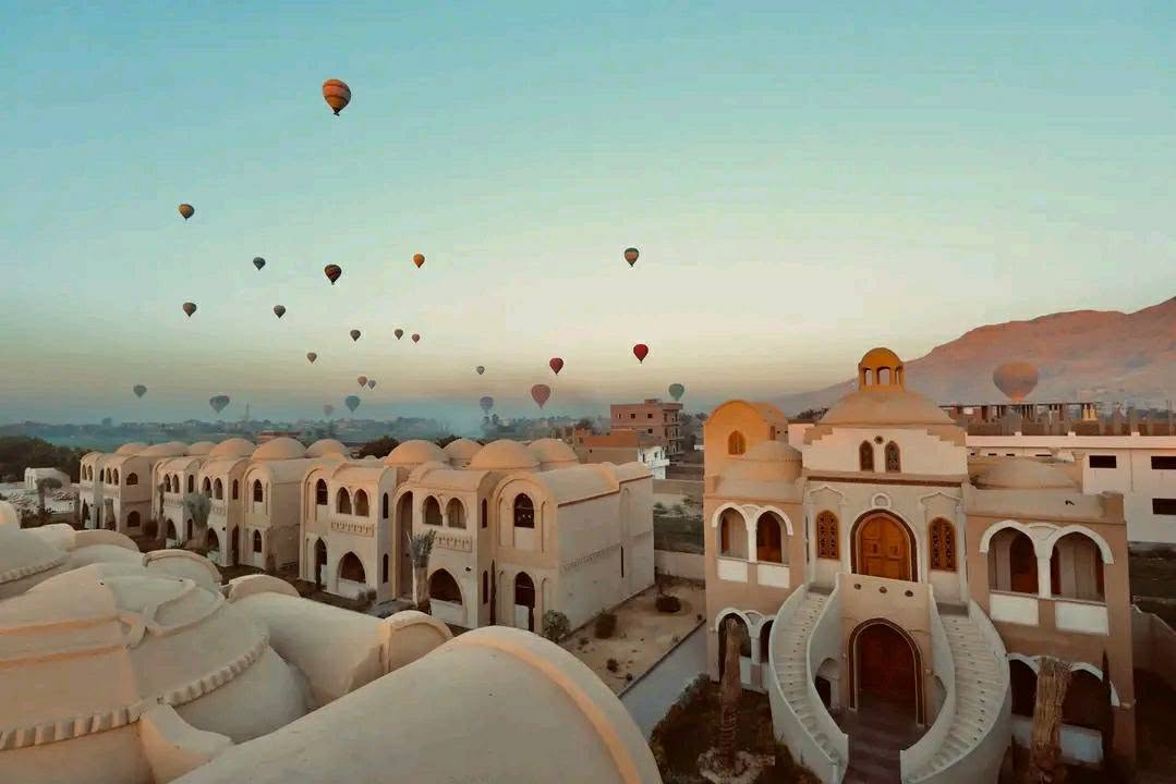 A hot air balloon drifting over the West Bank above the Omda retreat's garden and pool.