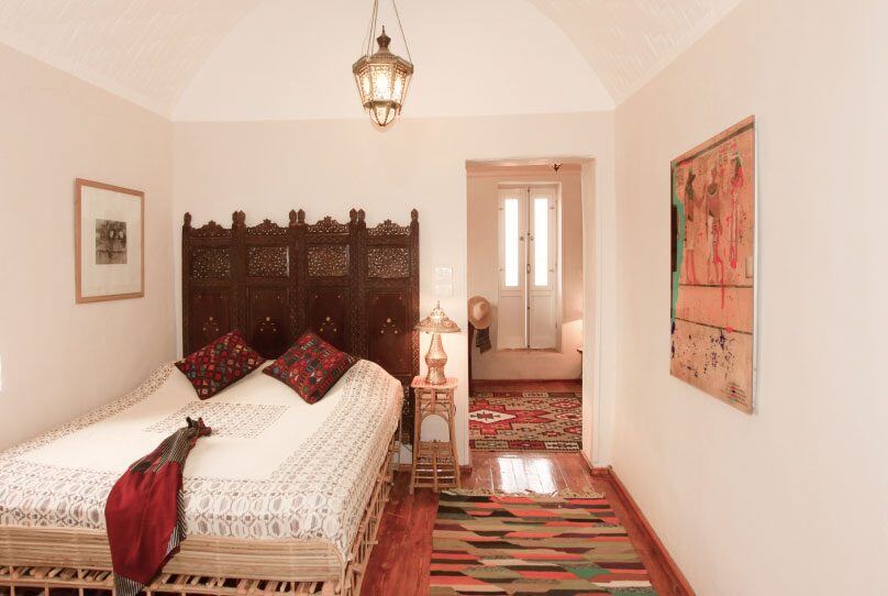 A double room: vaulted ceiling, carved screen, and kilims