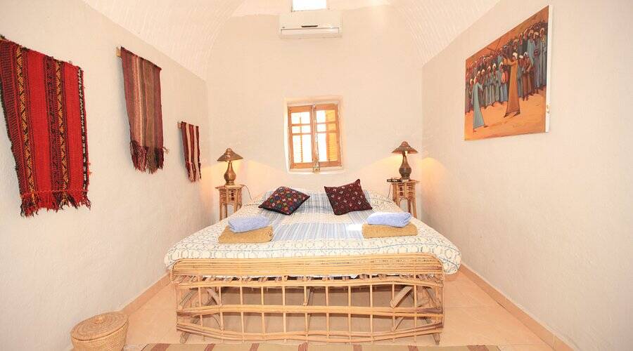 A Marsam room: vaulted ceiling, a wide bed, kilims and a painting on the walls