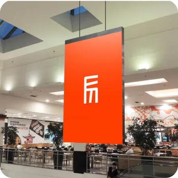 Um painel de LED suspenso com o logotipo da Eletromidia em um Shopping.