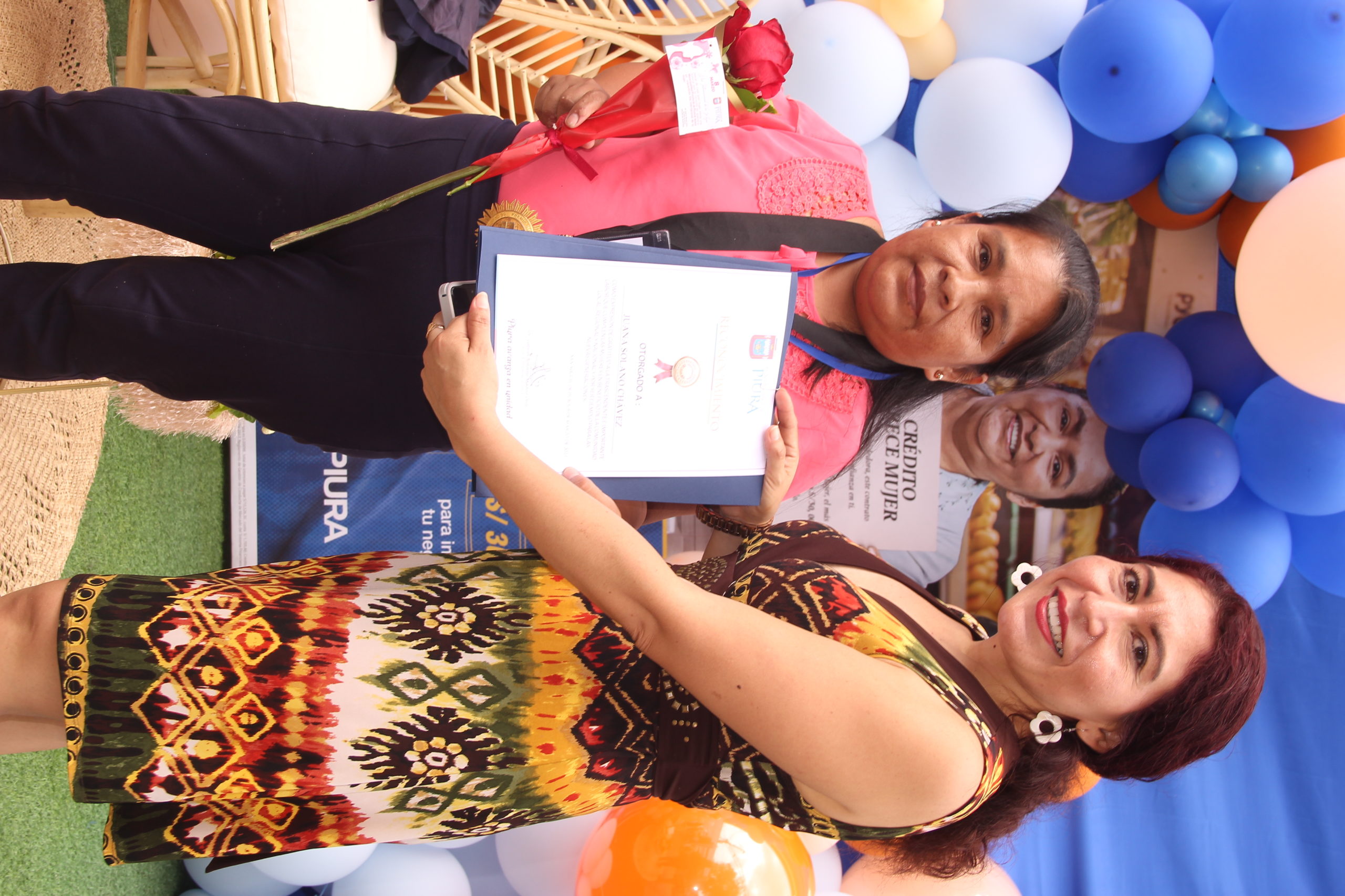 Juana Solano Chávez recibe su diploma de reconocimiento de parte de la funcionaria municipal Ruth Oliva.