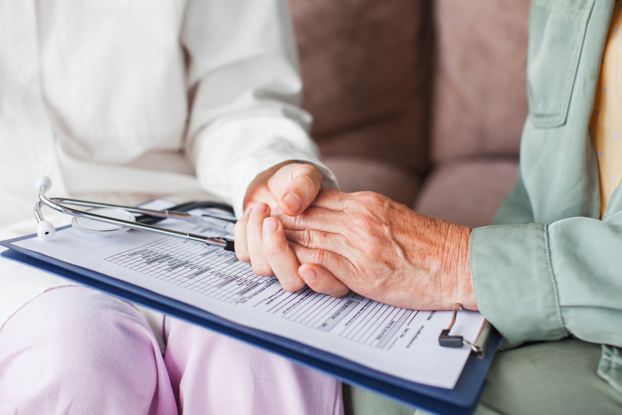 MISSCARE Survey Nurse holding elderly patients hand over clipboard