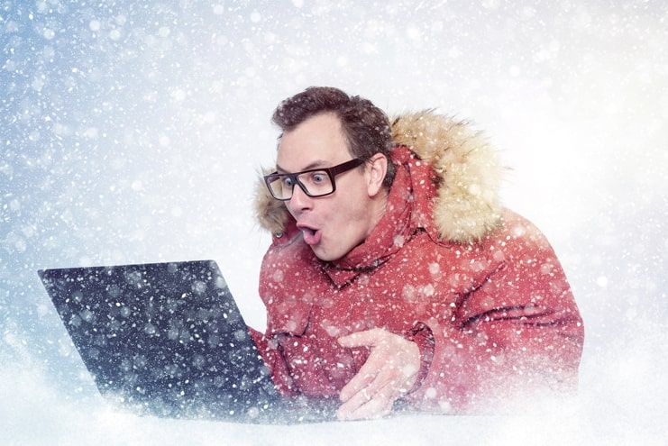 image of a man in cold environment looking at his laptop