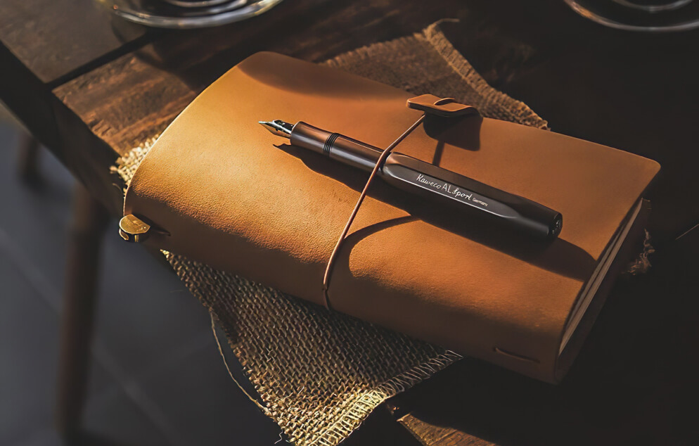 Leather journal and fountain pen on a wooden table