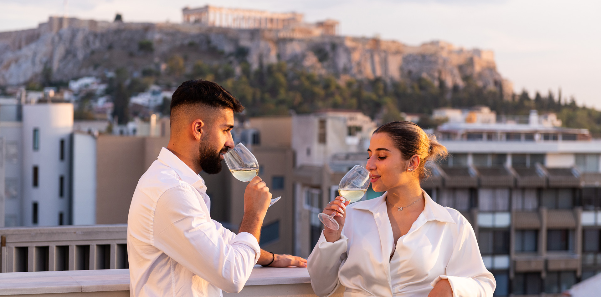 Enattica Suites, Ένα ζευγάρι πίνει κρασί με θέα την Ακρόπολη