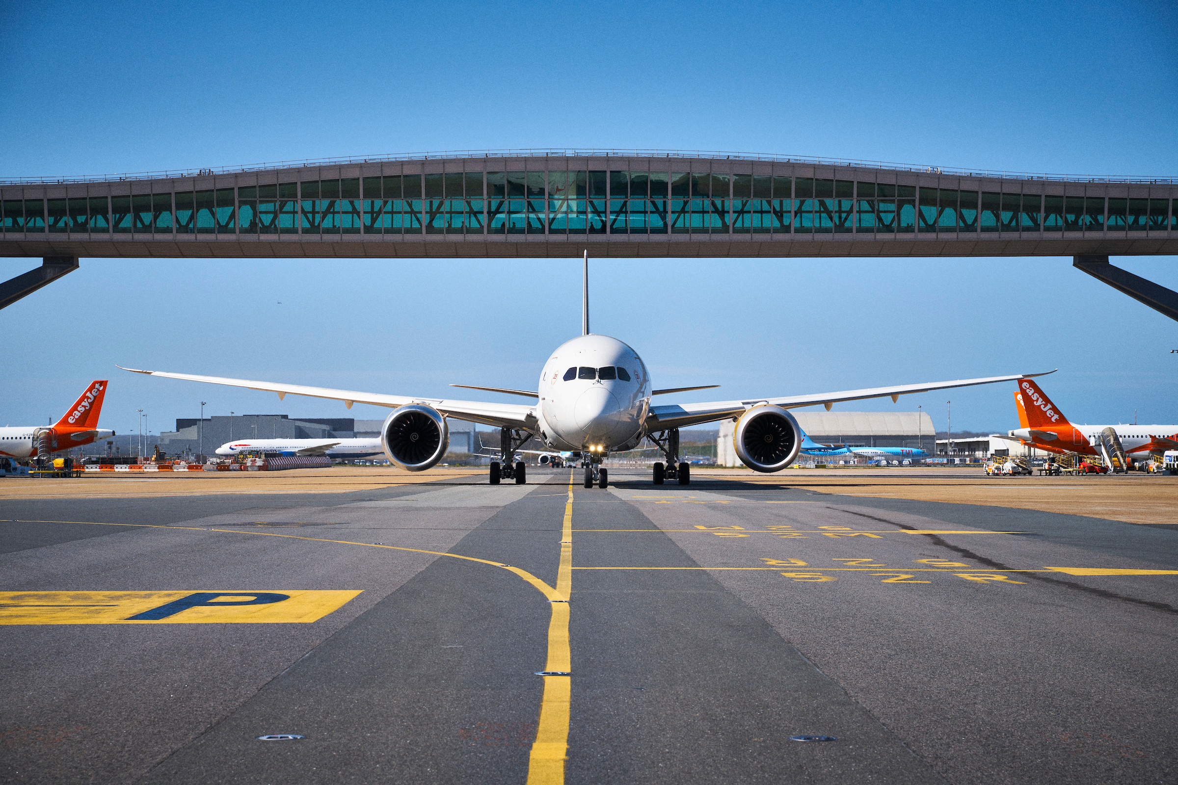 Aircraft taxiing at London Gatwick under the pier bridge