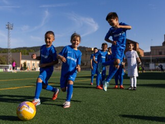 Jóvenes futbolistas en uniforme Allianz jugando fútbol base