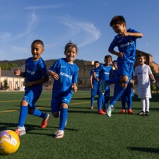 Jóvenes futbolistas en uniforme Allianz jugando fútbol base