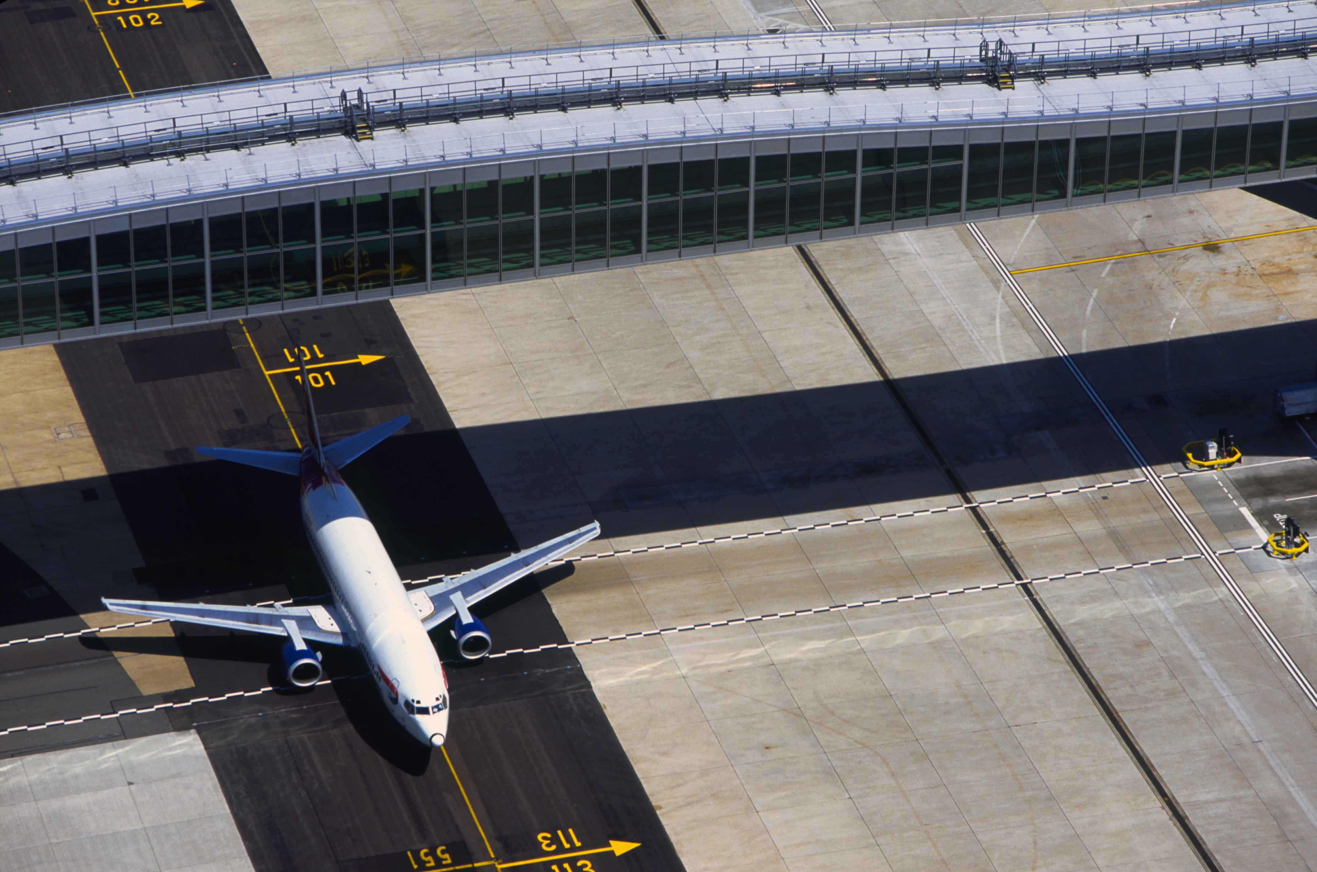 Airport facilities and infrastructure -aircarft passing under bridge to Pier 6, London Gatwick Airport.jpg