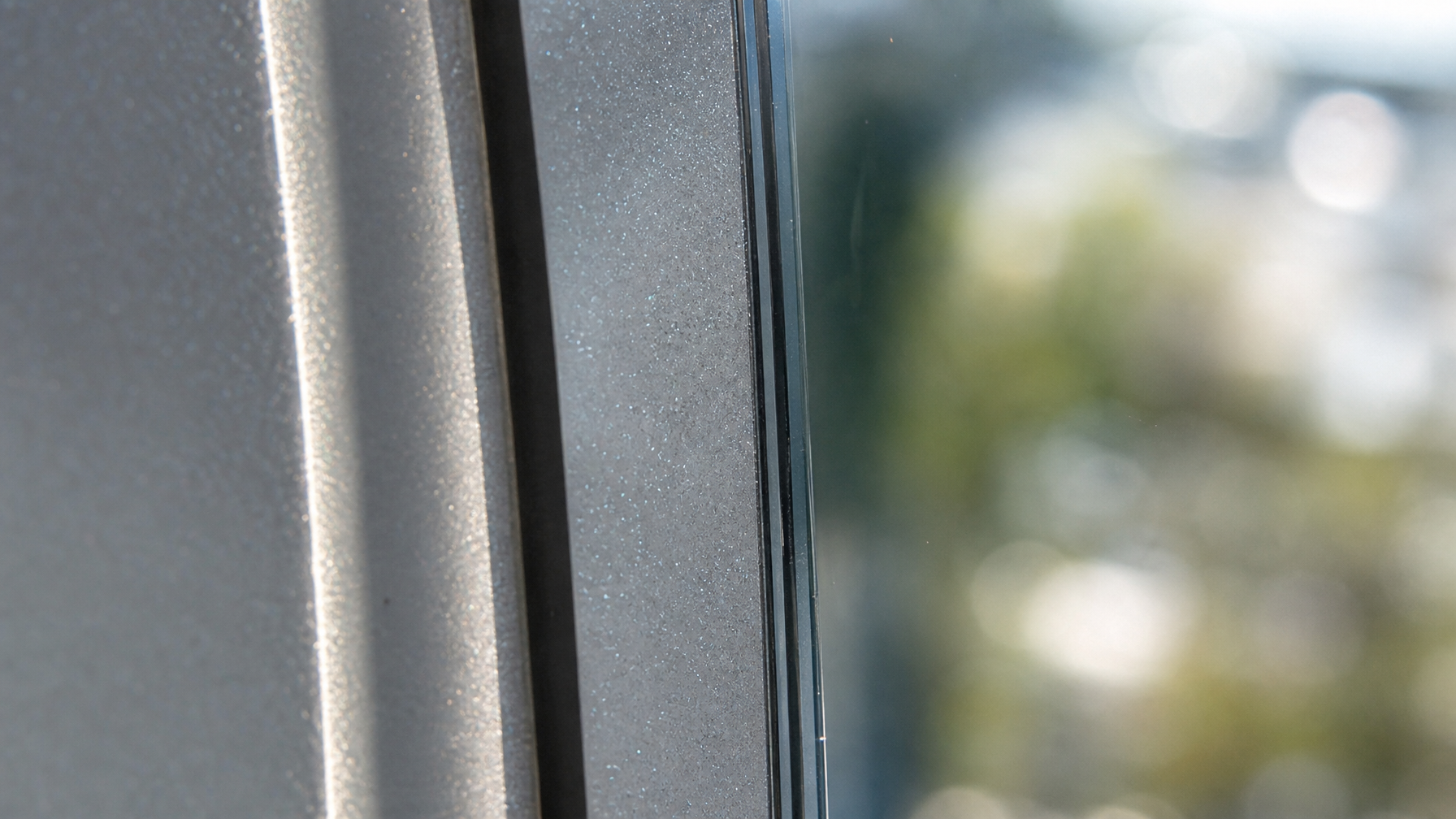 Close-up detail of professionally installed window film edge showing clean adhesive bond on glass
