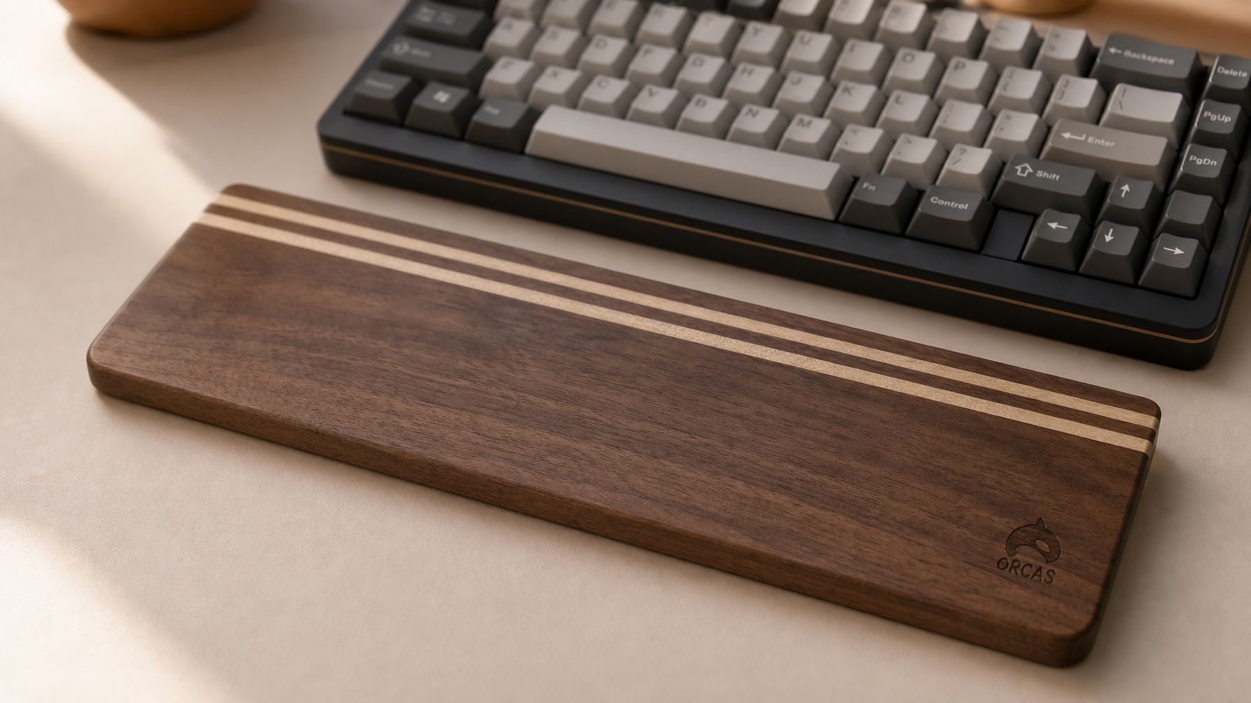 Walnut wood keyboard wrist rest on a minimal desk setup