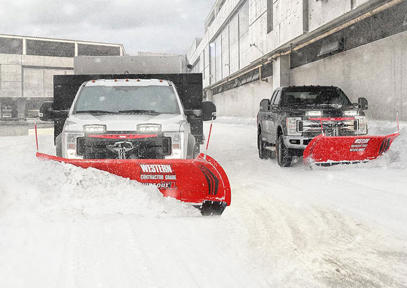 Western plows in action on trucks.